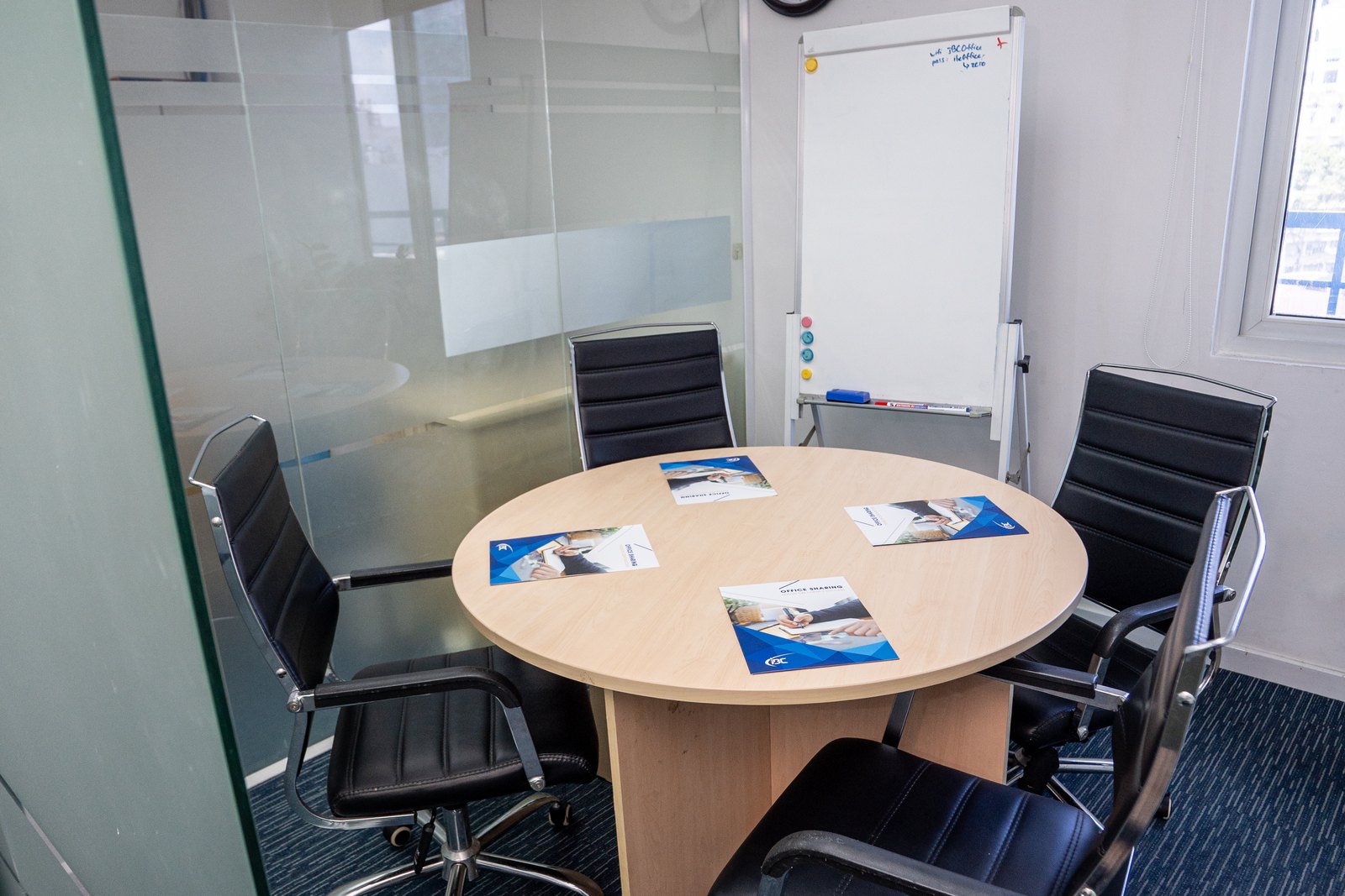 Meeting room at the Vietnam Business Center with a round table, executive chairs and a whiteboard, available to IBC clients by the hour