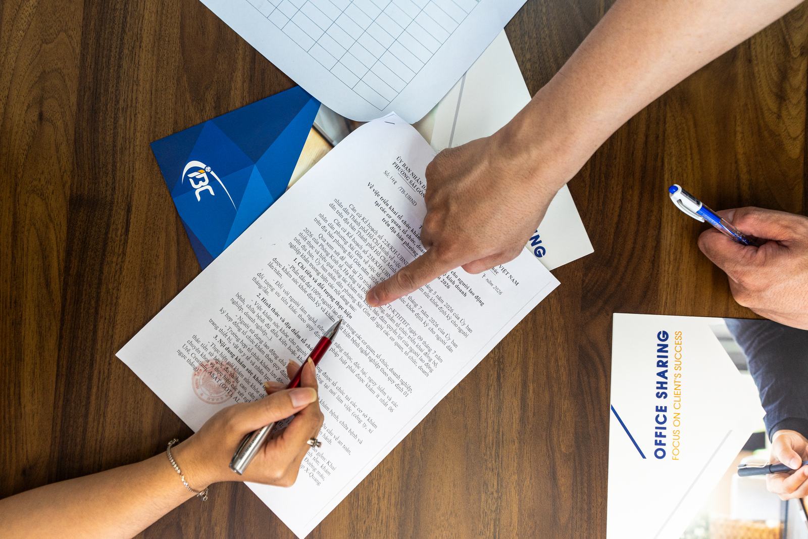 IBC consultants reviewing a stamped Vietnamese business registration document with a client